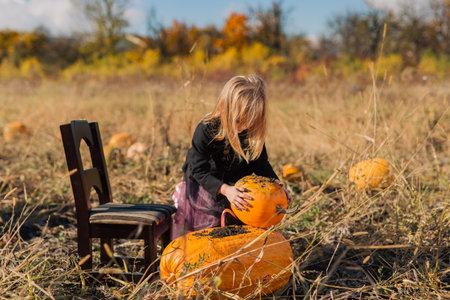 Child playing in the pumpkin field on Halloween