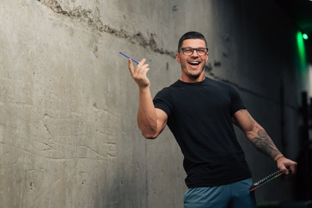 Young fitness trainer in the gym with clipboard and glasses pointingの写真素材