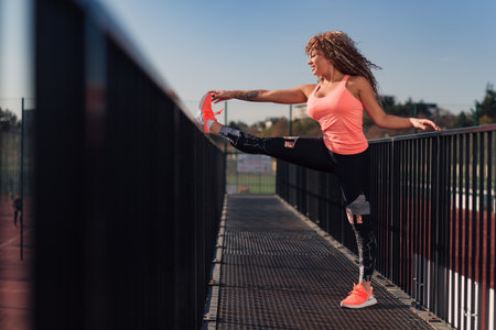 Young attractive woman stretching outdoor in an urban setting on a sunny day