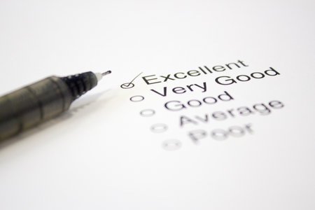 Feedback Questionnaire with  Excellent  ticked and a pen in foregroundの写真素材