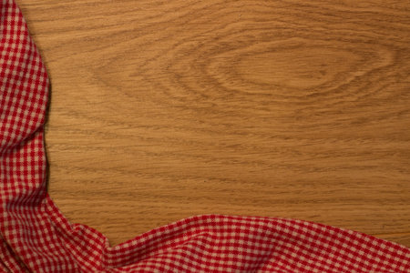 Red and White chequered tablecloth on wooden tableの写真素材