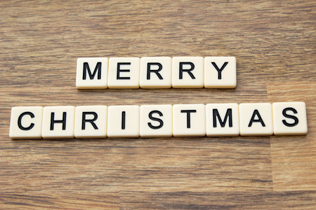 The word merry christmas written in tiles on a wooden surfaceの写真素材