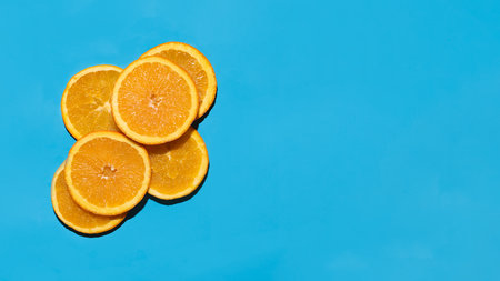 slices of oranges placed on top of each other against a blue backgroundの写真素材
