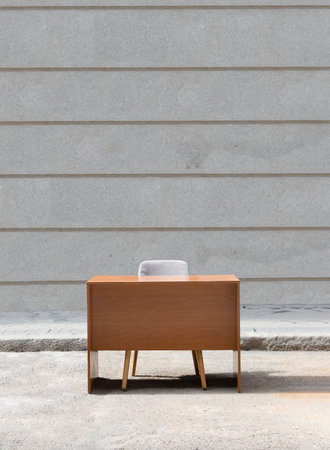 Wooden desk with chair placed on the street as if they were from an office. Routine break concept.の写真素材
