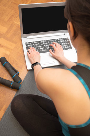 Young athletic woman using her laptopの写真素材