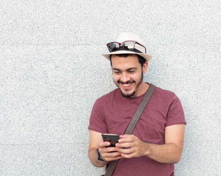 Young male tourist using his smart phone while smiling happily.の写真素材