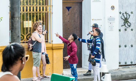 Cartagena, Colombia. April 2018. A view of a rap group singing in the street to a tourist in cartagena colombia.のeditorial素材