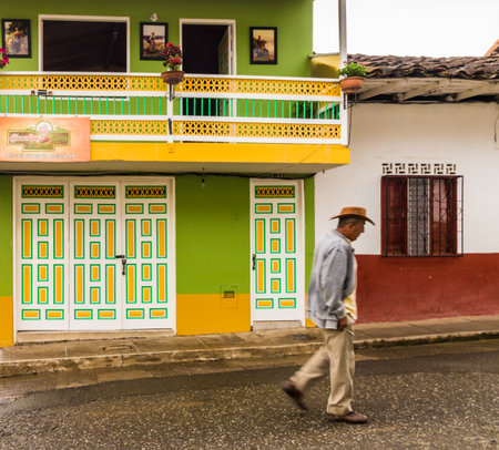 Jardin, Colombia. April 2018. A view of a colorful building with a blurred person walking past in the picturesque town of Jardin in Colombia.のeditorial素材