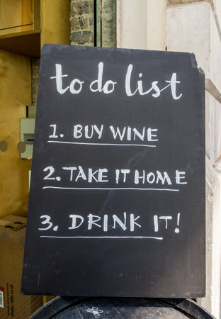 London. May 2018. A view of a to do list outside New street wine in the City of london in London.