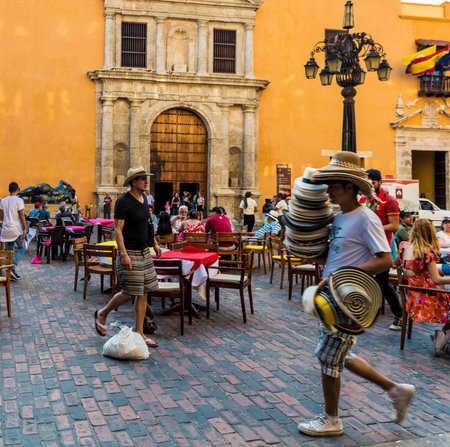 Cartagena, Colombia. April 2018. A view of a street vendor selling hats in Cartagena, Colombia.のeditorial素材