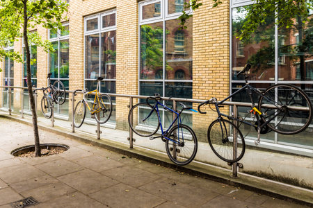 London. June 2018. A view of bicycles chained to a metal railing in Londonのeditorial素材