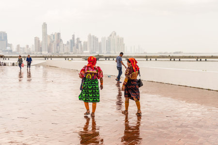 Panama City, Panama. March 2018. A view of colorfully dressed Kuna Yala women against the city skyline in Panama City in Panamaのeditorial素材