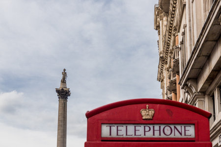 London. September 2018. A view of a red phone box and Nelsons column in the background in Westminster in Londonのeditorial素材