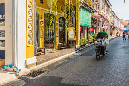 January 2019. Phuket Town Thailand. A local bike passing Colorful architecture in Phuket Town in Thailandのeditorial素材