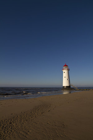 Point of Ayr Lighthouse, Wales UK  with an incoming tide at sunsetの写真素材