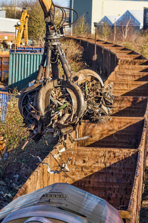 Grab crane loading scrap metal onto a trainの写真素材