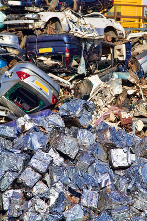 Cars crushed into cubes in foreground with those awaiting compaction in the backgroundの写真素材