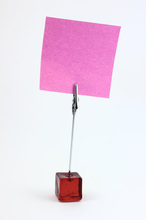 Red glass note-holder with alligator clip and blank pink note - isolatedの写真素材