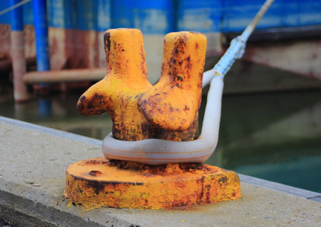 Orange metal pole for mooring of ships at pierの写真素材