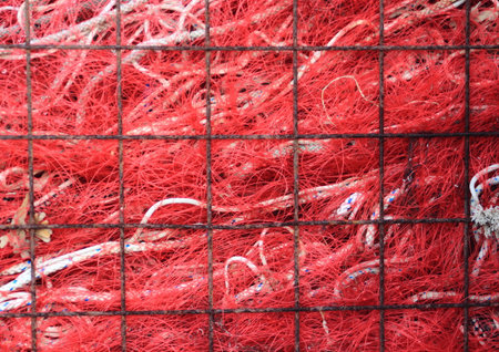Red industry fishing net in rusty metal gridの写真素材