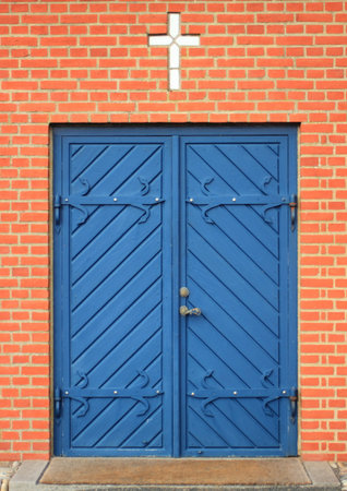 Isolated entrance to church with blue doors and white crossの写真素材