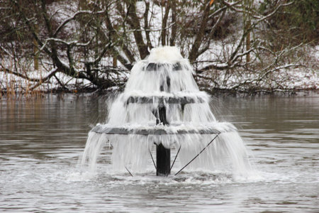 Small level fountain in pond at winter timeの写真素材