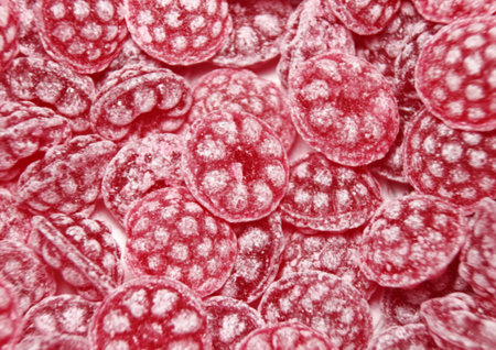 Pile of red sweet raspberry bonbons with sugar