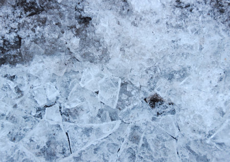 Broken cold ice on asphalt in winter