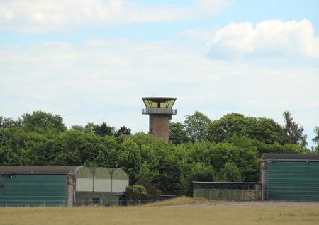 Airfield control tower hidden in forest with cloudsの写真素材