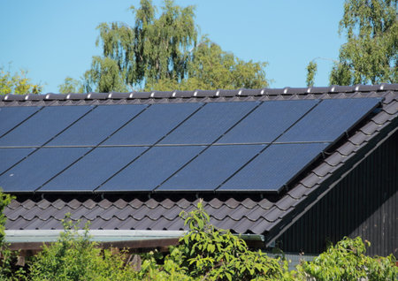 Solar collector on house roof with blue skyの写真素材