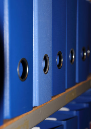 Row of blue A4 binders at office on a shelfの写真素材