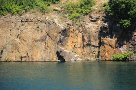 Lake with rocks and abrupt cliff hangの写真素材