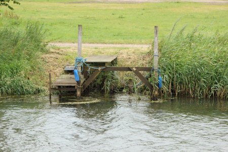 Vacant Landing Stage Jetty at Small River with Reedの写真素材