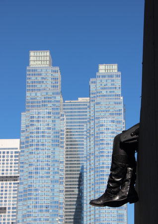 Resting Black Leather Boots with Skyscraper Background Abstractの写真素材