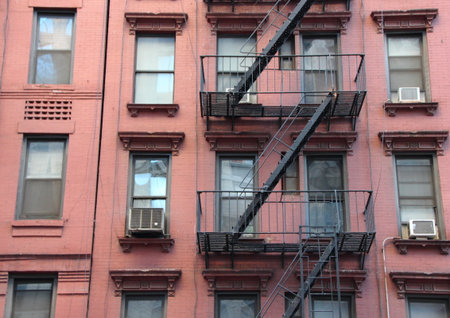 Fire Escape Steel Ladder on Urban Red Apartment House Facade in New Yorkの写真素材