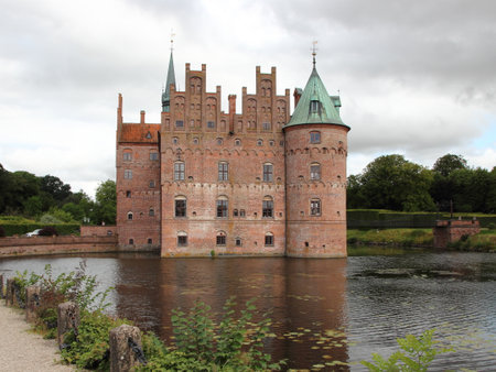 Egeskov Castle Denmark and Pond with Overcast Skyのeditorial素材