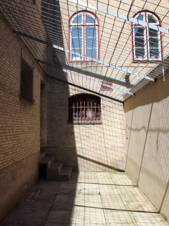 Inside of Jail Yard with Metal Grid Roof and Red Barsの写真素材