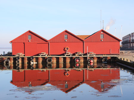 Red Fishermen Buildings in Winter with Reflection on Cold Water