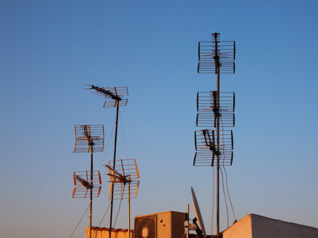 Tall Metal Antennas on Roof with Blue Sky at Duskの写真素材
