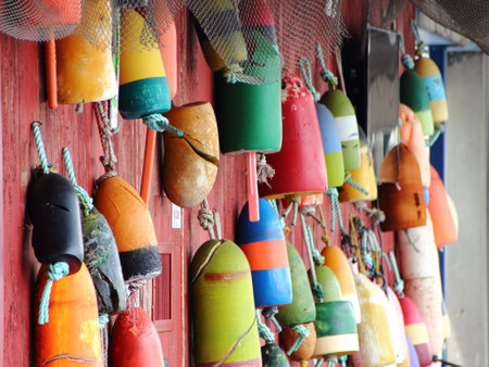 Colored old Fishing Net Floats on Worn Red wooden Wall