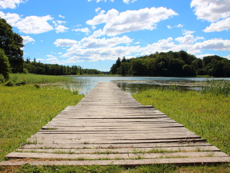 Empty Endless Svimming Pier in Bright Dayligt with Blue Sky and Silent Waterの写真素材