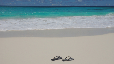 with slippers to the colorful indian oceanの写真素材