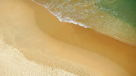 aerial of a girl with mobile on a beachの写真素材