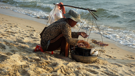 Otres, Cambodia- March 2018: local woman preparing fresh fish on the beachのeditorial素材