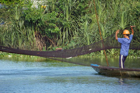 hue, vietnam, circa january 2020: Fisherman collects fish from netのeditorial素材