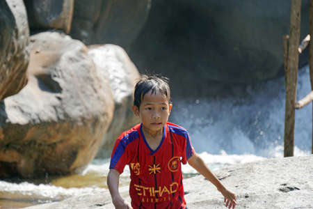 hue, vietnam, circa january 2020: young asian boy playing at waterfallのeditorial素材