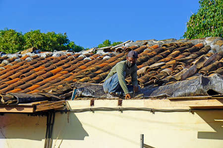 Trinidad, Cuba, circa May 2022: roofer fixing rotten roofのeditorial素材