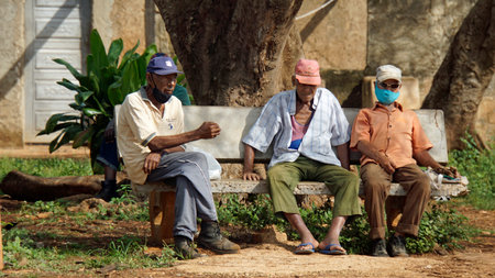 Limonar, Cuba, circa May 2022: 3 old men sitting on a bench in central parkのeditorial素材