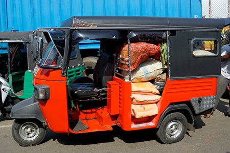 overloaded red tuktuk in the streets of Colomboの写真素材