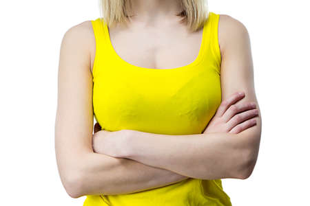 Woman in yellow T-shirt with arms crossed - isolated photoの写真素材